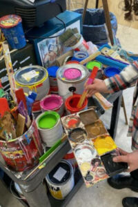 Student mixing paint for the Pickets for Peace Project